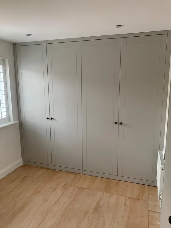 Fitted wardrobe in a Colchester bedroom with four sprayed shaker doors running floor to ceiling