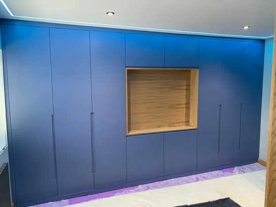 Finished fitted wardrobe in Harwich with handleless painted doors and a central oak recess