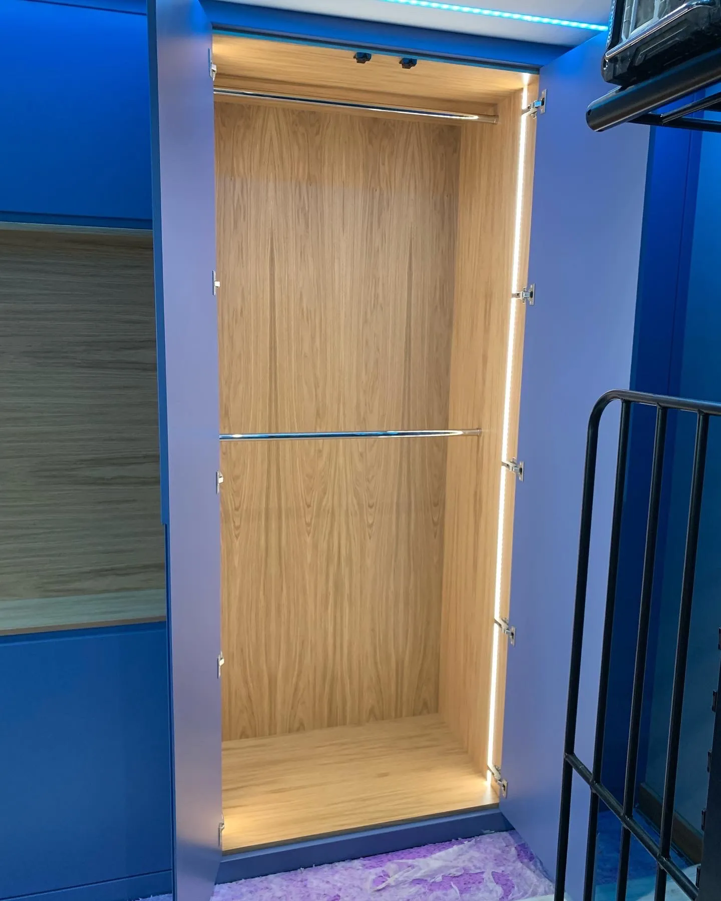 Lit oak hanging space inside a fitted wardrobe in Harwich