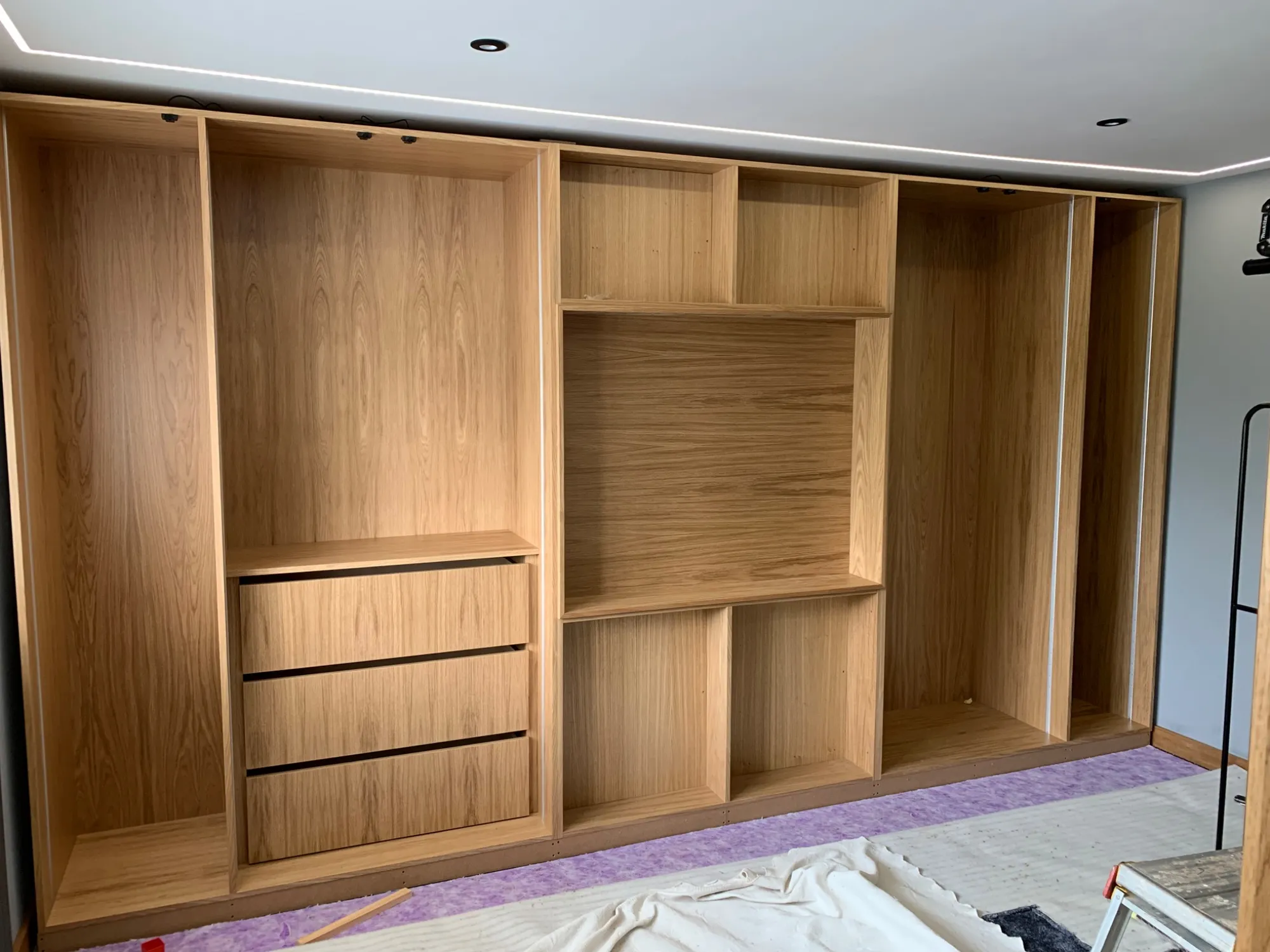 Oak wardrobe carcasses fitted along the wall in Harwich before the doors were hung