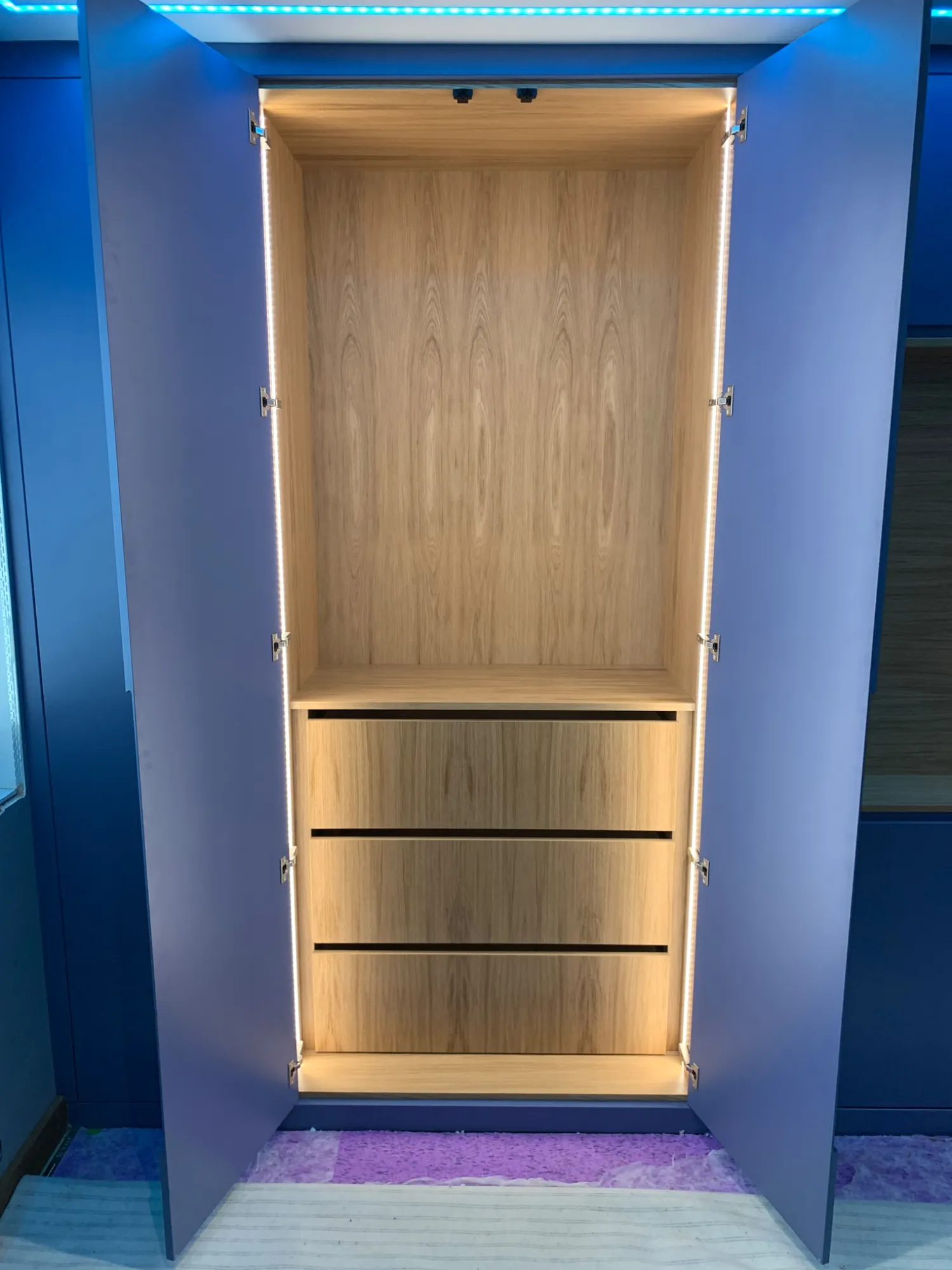 Fitted wardrobe in Harwich open to show the lit oak interior and drawers