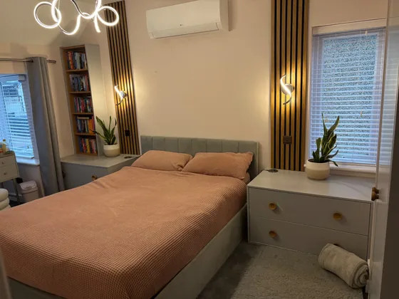 Manningtree bedroom with oak wall panelling, fitted bedside units and an oak book unit
