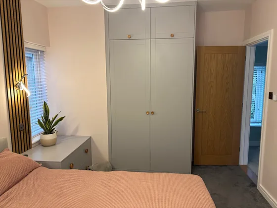 Bespoke fitted wardrobe in a Manningtree bedroom with top boxes and a matching bedside unit