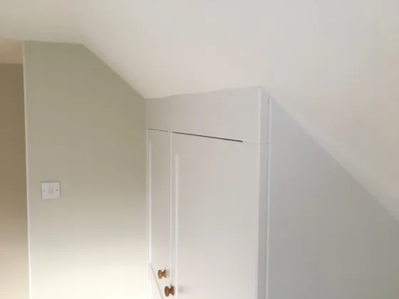 Detail of a fitted wardrobe in Dedham scribed to follow the angled ceiling