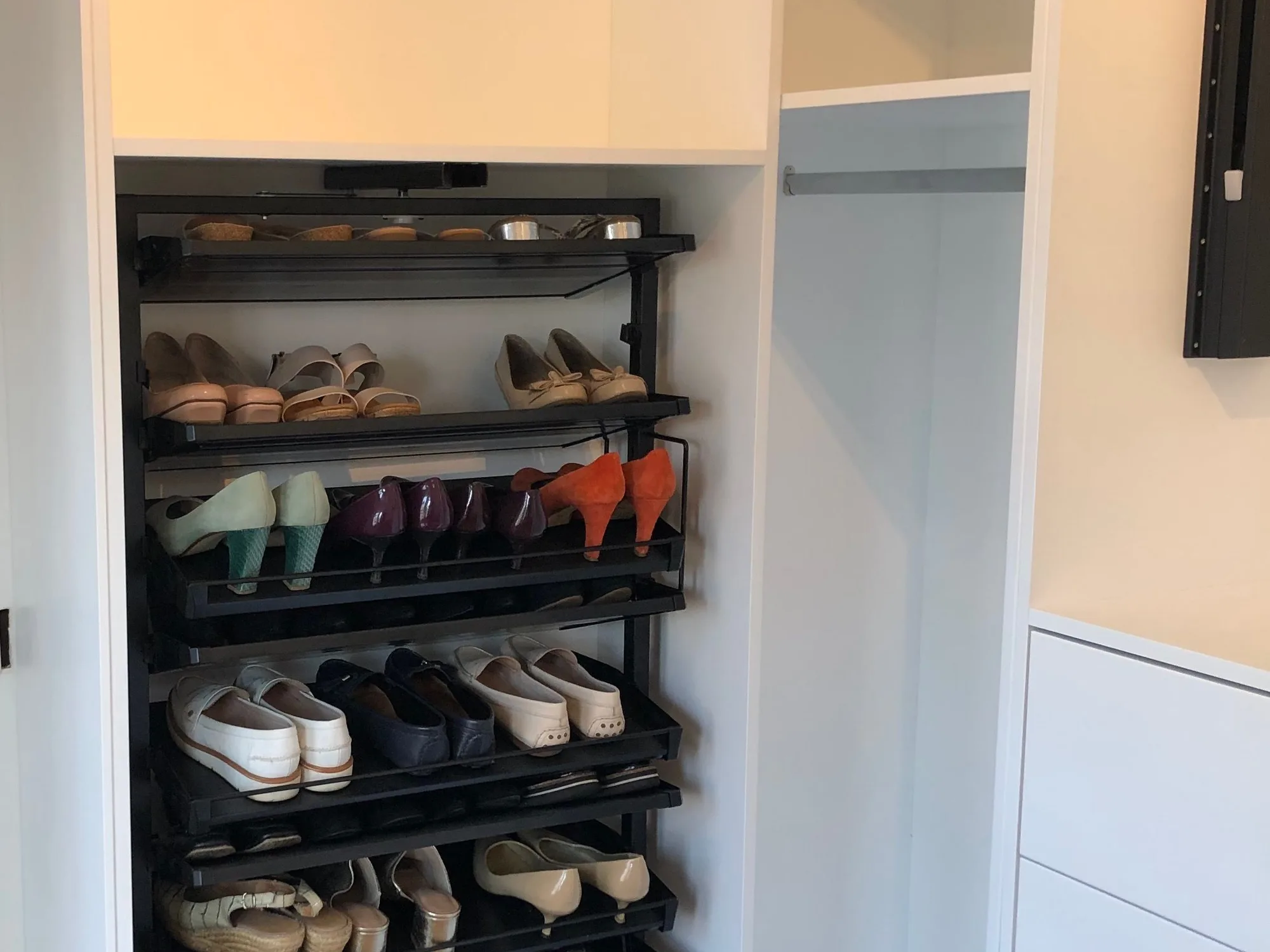Bespoke fitted dressing room with white drawer banks and pull-out shoe rack