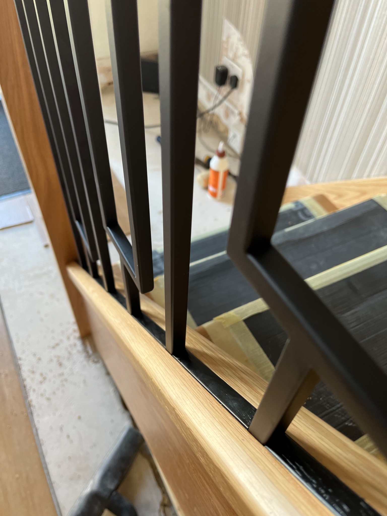 Close up of the oak handrail and black metal spindles being fitted in Harwich