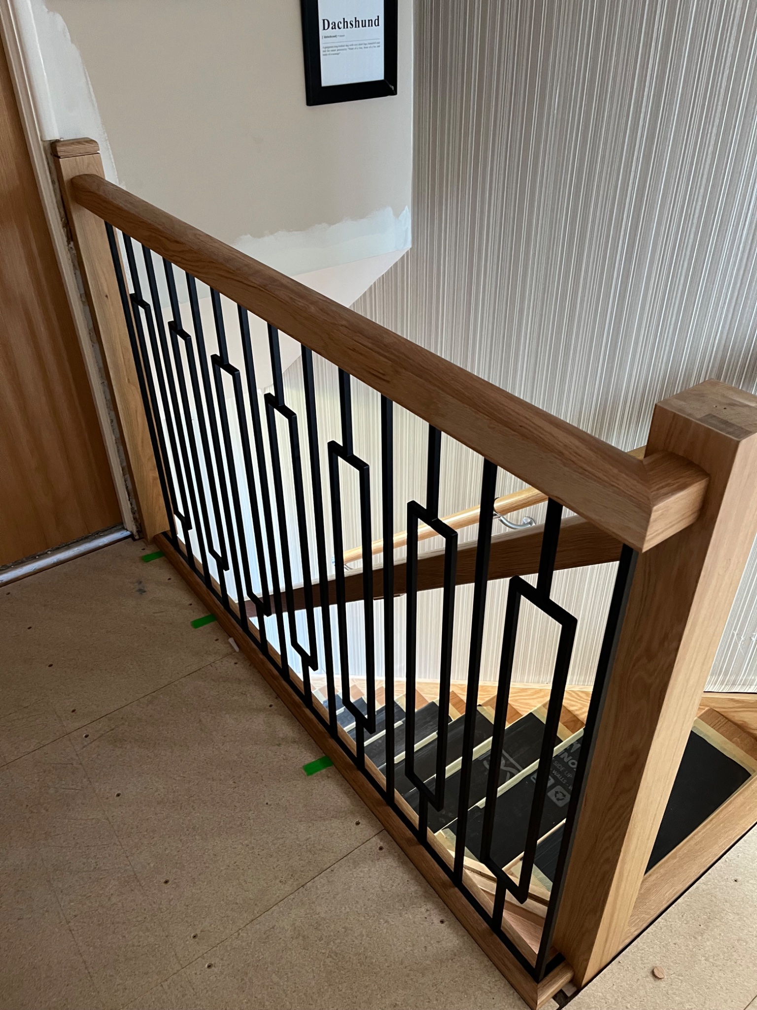 New oak newel post and black metal balustrade on a staircase renovation in Harwich